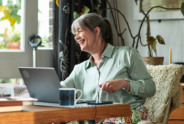 Woman smiling in front of laptop